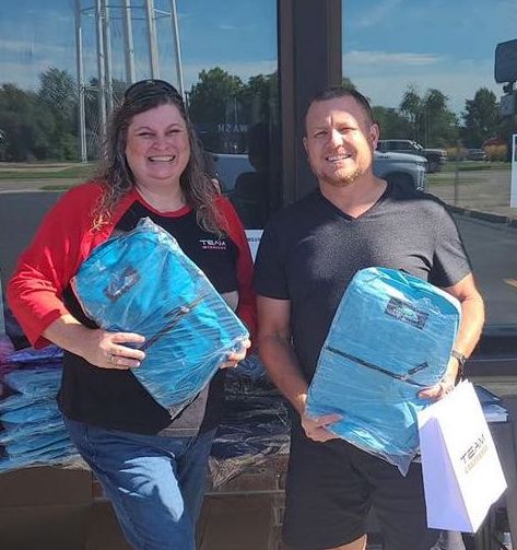 Team Verizon Store Manager Tara Root and Cooperative CEO Josh Shallenberger holding backpacks